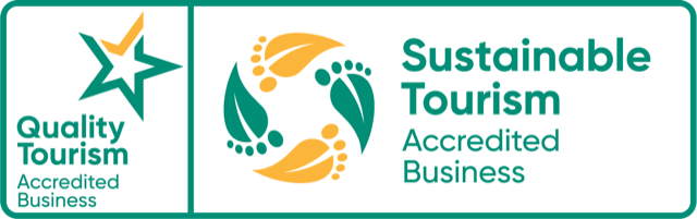 Logos for Quality Tourism and Sustainable Tourism Accredited Business with star and leaf designs.