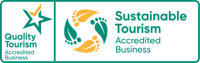 Logos for Quality Tourism and Sustainable Tourism Accredited Business with star and leaf designs.
