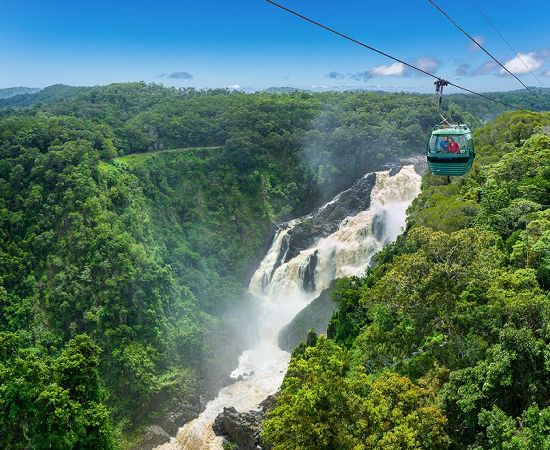 2023-kuranda-luxury-3 a train on a track with smoke coming out of the water