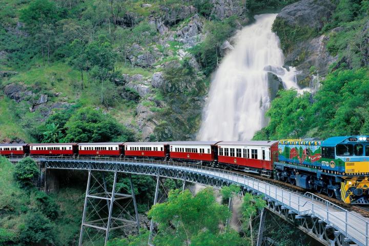 a large long train on a train track with trees in the background