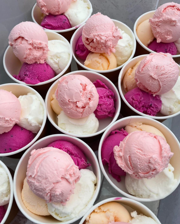 Cups filled with various scoops of pink, purple, and white ice cream.
